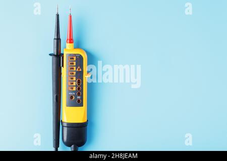 Two-pole voltage indicator close-up on a blue background. Testing and verification of electrical networks Stock Photo