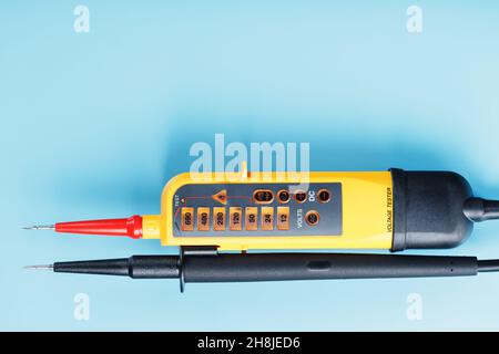 Two-pole voltage indicator close-up on a blue background. Testing and verification of electrical networks Stock Photo