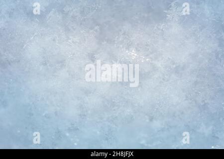 Snowflake glowing on snowy texture. Macro photo of real snow crystal. Stock Photo