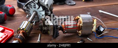 Details of electrical appliance and repair tools on a wooden table in a repair shop Stock Photo