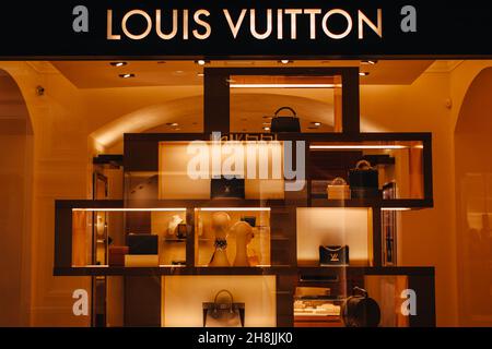 Louis Vuitton boutique with golden logo for advertising. Female fashion handbags at the display window. The company is one of the world's leading fash Stock Photo