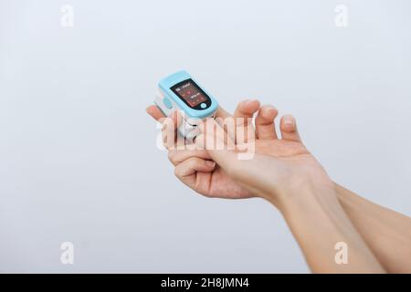 Pulse oximeter with hand of doctor isolated on white. The concept of portable digital device to measure person's oxygen saturation. Measuring oxygen Stock Photo