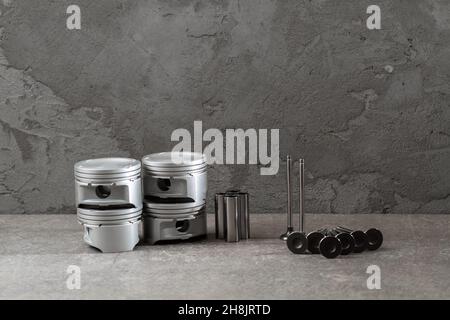 Set of new car pistons and valves on concrete gray background, car repair parts, copy space Stock Photo