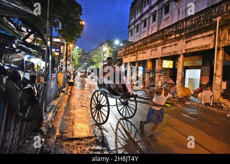 Kolkata’s Rickshaw Pullers. The dense metropolis is among the only places in India — and one of the few left in the world — where fleets of hand-pulled rickshaws still ply the streets. Kolkata, India. Stock Photo