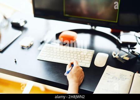 Businesswoman working from home, using multiple screens Stock Photo