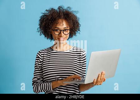 Joyful young woman using notebook in studio Stock Photo