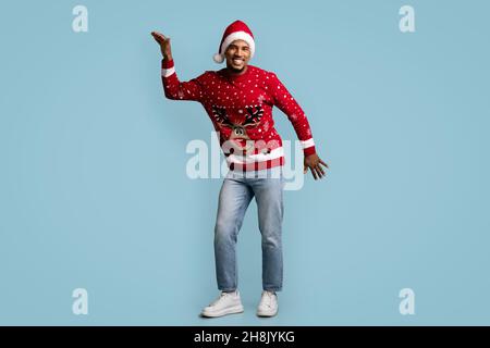 Funny black guy celebrating Christmas on blue background Stock Photo