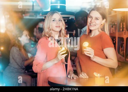 Two young women with cocktails having fun on party at nightclub Stock Photo