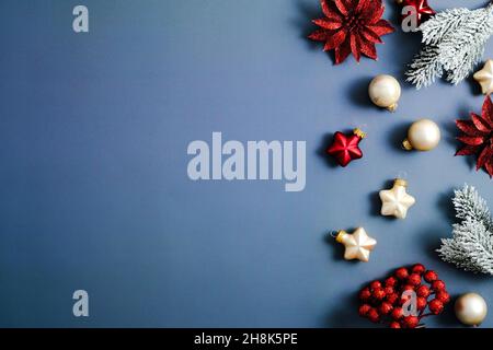 Christmas frame. Blue Xmas background with fir branches, stars, balls and red flowers. Christmas greeting card template, banner mockup. Flat lay, top Stock Photo