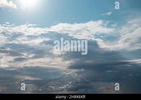 Sun shining on stormy sky with heavy cloudscape background. Skyscape natural heavenly scenery in summertime above sea Stock Photo