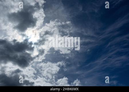 Sun shining on stormy sky with heavy cloudscape background. Skyscape natural heavenly scenery in summertime above sea Stock Photo