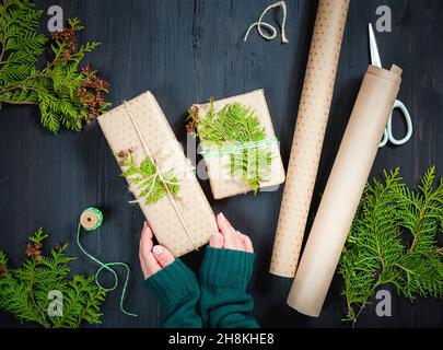 Wrapping Christmas gift boxes in craft paper Stock Photo