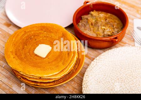 Thin pancakes with butter and mochanka of meat and mushrooms Stock Photo