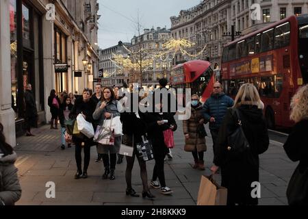 London, Britain. 24th Nov, 2021. People with shopping bags walk on Regent Street in London, Britain, Nov. 24, 2021. Consumers across Britain are expected to face higher prices and fewer choices for goods this Christmas season due to supply chain delays and soaring inflation. TO GO WITH 'Economic Watch: Supply chain delays, inflation surge across UK may lead to 'tough' Christmas' Credit: Tim Ireland/Xinhua/Alamy Live News Stock Photo