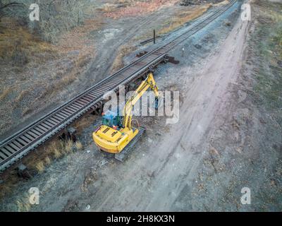 backhoe excavator and railroad track and trestle - aerial view in fall scenery, Stock Photo