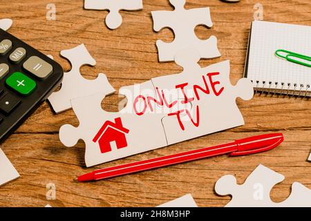 Handwriting text Online Tv. Concept meaning a television production broadcast in realtime as events happen Building An Unfinished White Jigsaw Pattern Stock Photo