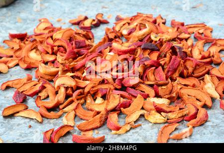 Organic dried fruit, dried apples. A close up of dry apple slices dried on a metal surface. Stock Photo