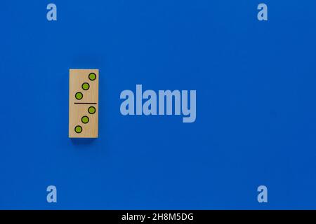 Top view of wooden dominoes gaming double piece with three spots on with copy space on blue background Stock Photo