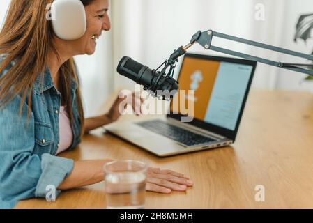 Woman in headphones recording podcast Stock Photo
