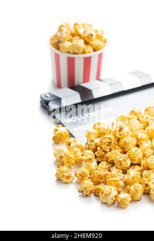 Sweet caramel popcorn and clapper board isolated on white background. Stock Photo