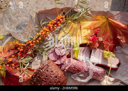 Autumn simple still life with food, maple leaves, ripe sea buckthorn and beer Stock Photo