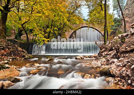 The old stone, arched bridge, between two waterfalls in Palaiokaria, Trikala prefecture, Thessaly, Greece. Stock Photo