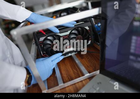 Man mechanic installing cooler fan with copper tubes on computer processor Stock Photo