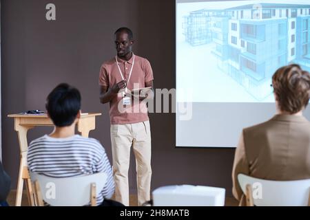 African young businessman using digital tablet presenting his project to business people during a presentation Stock Photo
