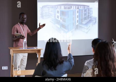 African young architect with digital tablet pointing at whiteboard with new modern building during a presentation Stock Photo