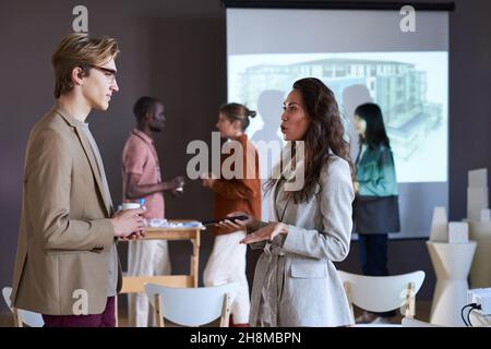 Businesswoman talking to businessman during a break at the seminar Stock Photo