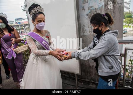 A woman receives condoms from Panurat Noibunjong "Miss LGBT Thailand friendship 2021" during the World AIDS day 2021 campaign activities.World AIDS day 2021 campaign activities were held in Ratchathewi district, Bangkok at the victory monument to mark the World AIDS day 2021. The theme of World AIDS Day 2021 from World Health Organization (WHO) is 'End inequalities. End AIDS'. “With a special focus on reaching people left behind and highlighting the growing inequalities in access to essential HIV services. (Photo by Peerapon Boonyakiat/SOPA Images/Sipa USA) Stock Photo