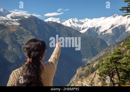 Woman tourist traveler get an aerial view of scenic Himalaya mountain landscape at Kalpa Himachal Pradesh, India Stock Photo