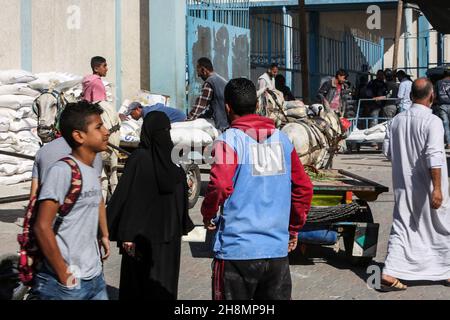 Palestinians receiving food aid for the new cycle from a UN (UNRWA) distribution center in Rafah camp in Gaza Strip, on Nov 30, 2021. Stock Photo