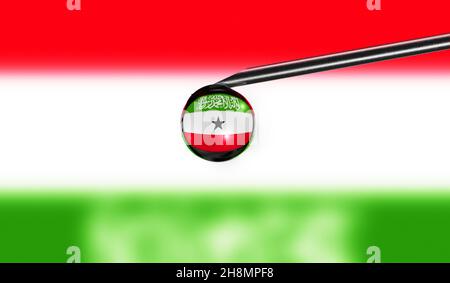 Vaccine syringe drop on needle against national flag of Somaliland background. Medical concept vaccination. Coronavirus Sars-Cov-2 pandemic protection Stock Photo