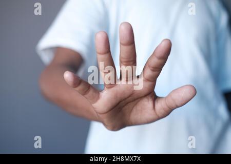 young man show stop sigh isolated in black  Stock Photo