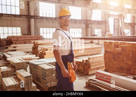 Cheerful male worker standing by construction materials Stock Photo