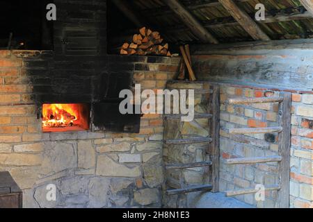 Fire in a wood-burning oven, open-air museum Neuhausen ob Eck, Upper Danube nature Park, Baden-Wuerttemberg, Germany Stock Photo