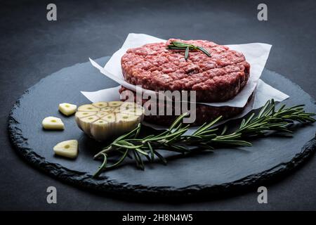 Raw burger beef patty on stone background Stock Photo