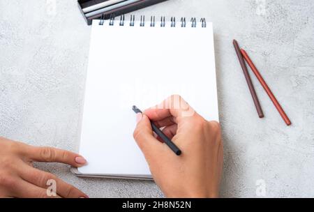 Girl's hands drawing in notebook Stock Photo