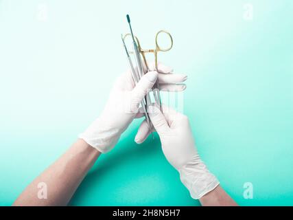 Hands in gloves holding medical tools Stock Photo