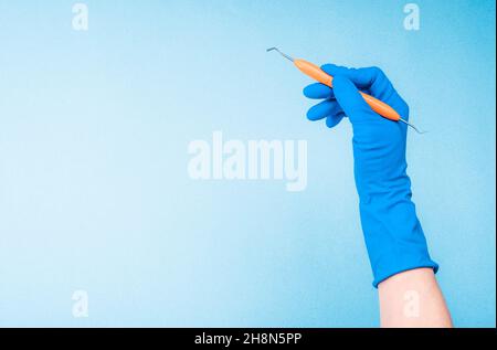 Hand in blue glove holding dental tweezers Stock Photo