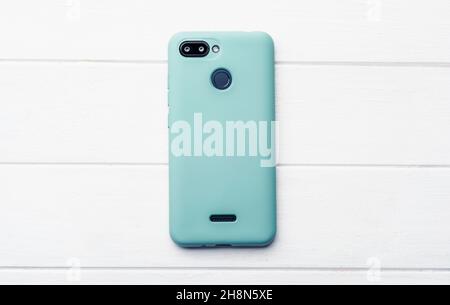 Smartphone in blue case on the wooden floor, with free space Stock Photo