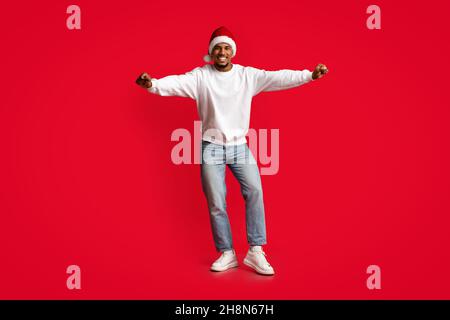 Joyful african american guy in Santa hat having fun Stock Photo
