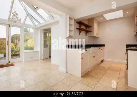 Cambridgeshire, England - November 4 2019: Brightly decorated open plan kitchen and conservatory area inside vacant empty english cottage Stock Photo