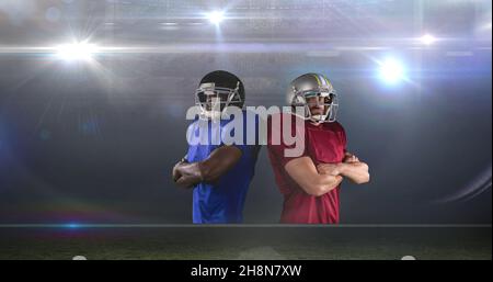 Portrait of rival american football players standing back to back with arms crossed Stock Photo