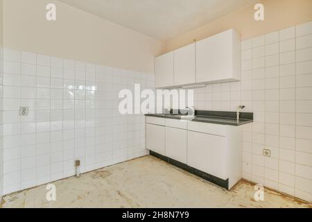 Miniature kitchen with black worktop in an elegant apartment Stock Photo