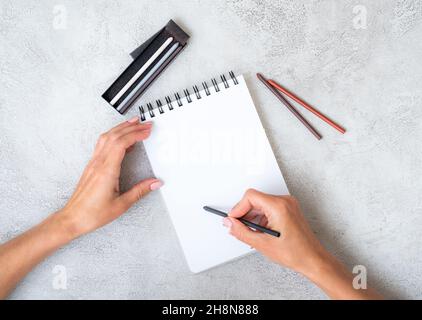 Girl's hands drawing in notebook Stock Photo
