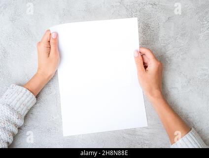 Girl's hands holding sheet of paper Stock Photo