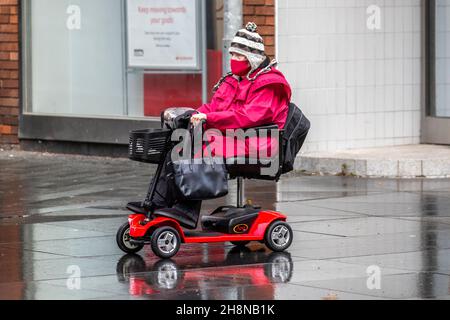 Southport, Lancashire.  UK Weather 01 Dec 2021. Christmas shops, shoppers shopping on a wet and windy day in the town centre. This morning's rain will clear southwards, but fresh to moderate northerly winds will persist adding a considerable chill factor. Credit MediaWorldImages/AlamyLiveNews Stock Photo