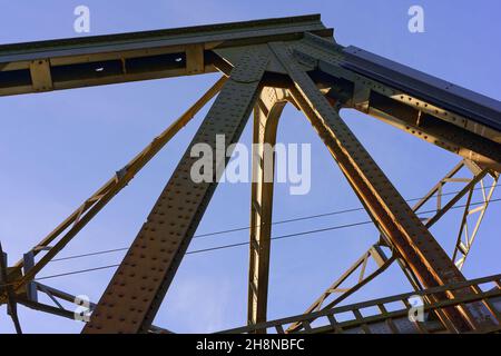 Eisenbahnbrücke vor blauem Himmel, Konstruktionsdetails mit Nieten, wenig Wolken Stock Photo